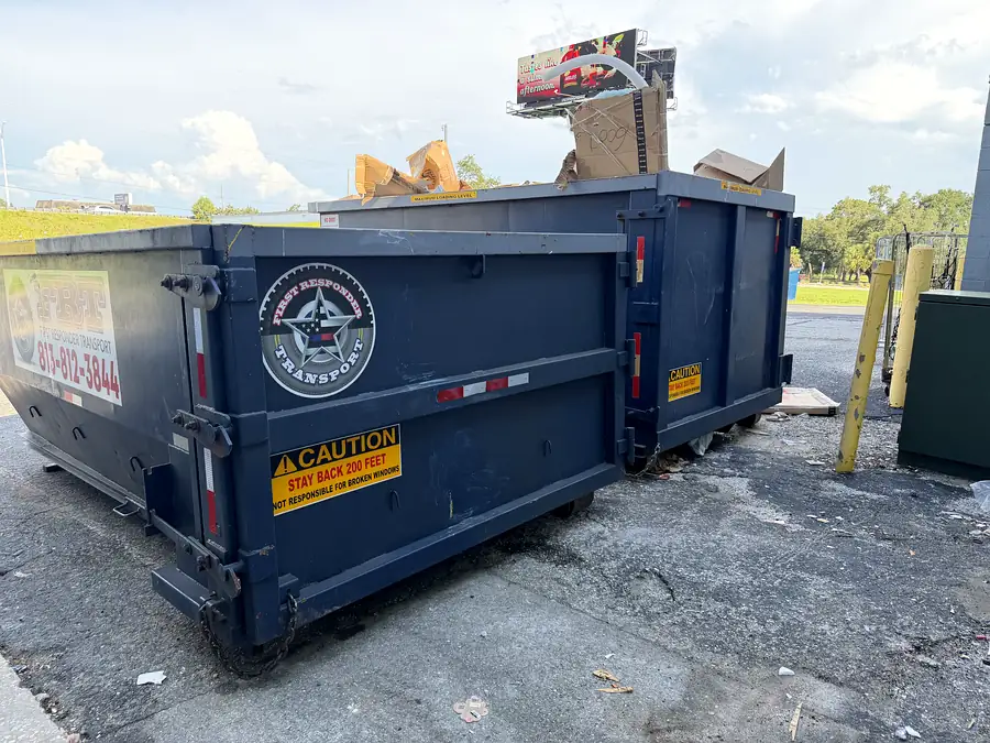 A roll-off can loaded level with cardboard and timber
