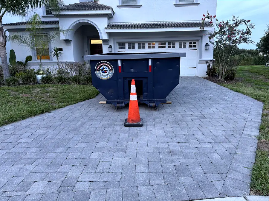 A roll-off can set on a paver driveway at a residential house