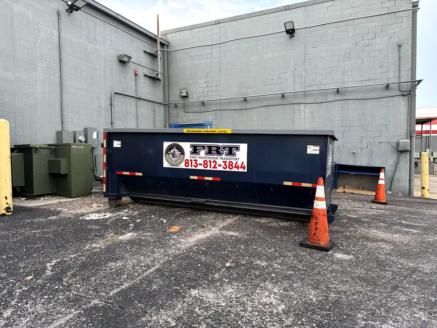 A dumpster staged behind a commercial building