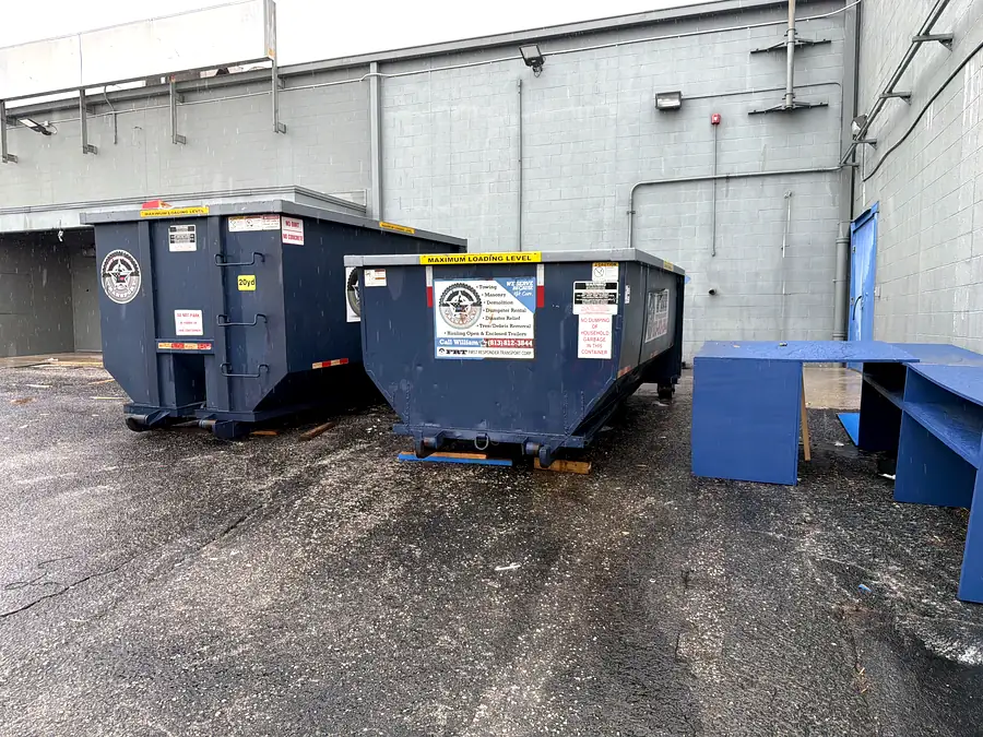 Two FRT roll-off cans staged at a commercial site