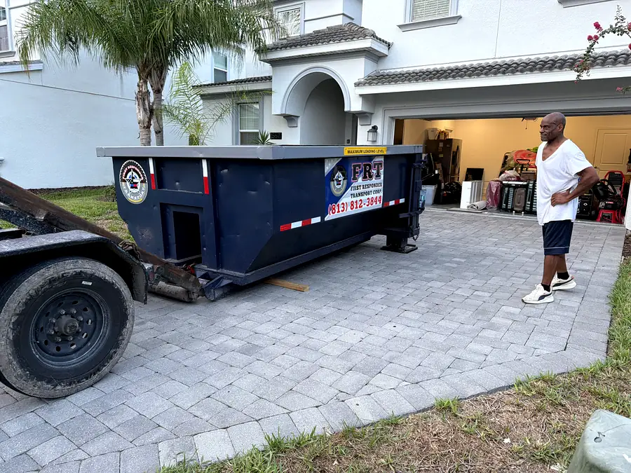 A can dropped on a driveway beside an open garage