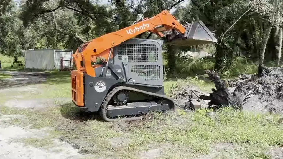 The tracked skid steer clearing a lot